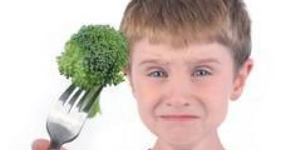 un jeune garçon fait un visage dégoûtant drôle à une fourchette avec un morceau sain de brocoli sur un fond blanc
