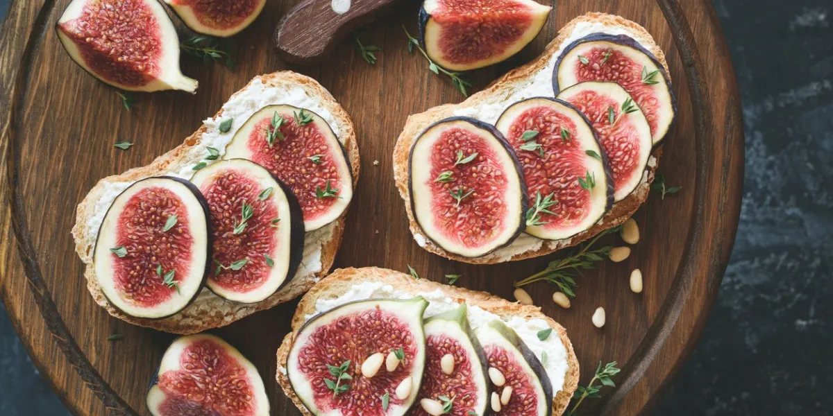 fig and goat cheese toasts on wooden cutting board top view