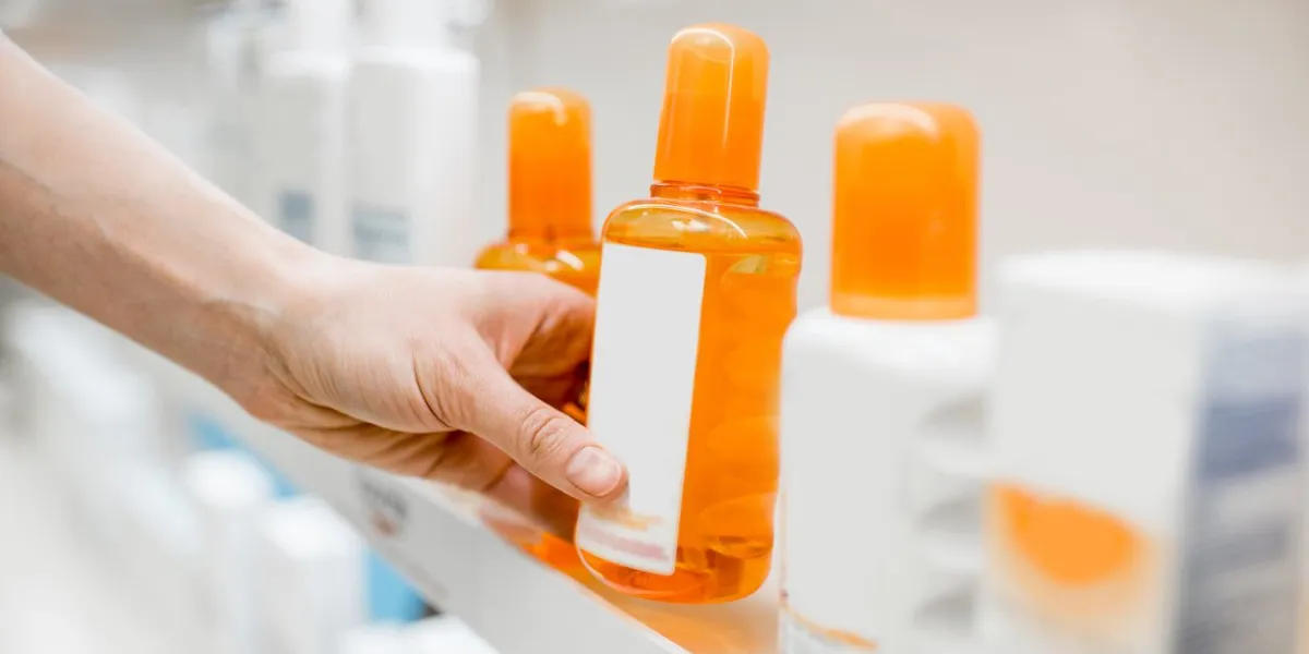 taking sunscreen lotion from the shelves of the pharmacy store, close-up view