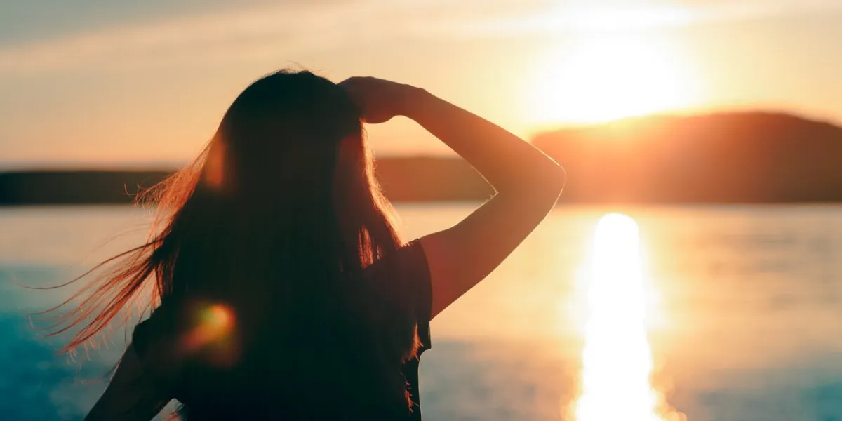 silhouette of a dreamer girl looking hopeful at the horizon