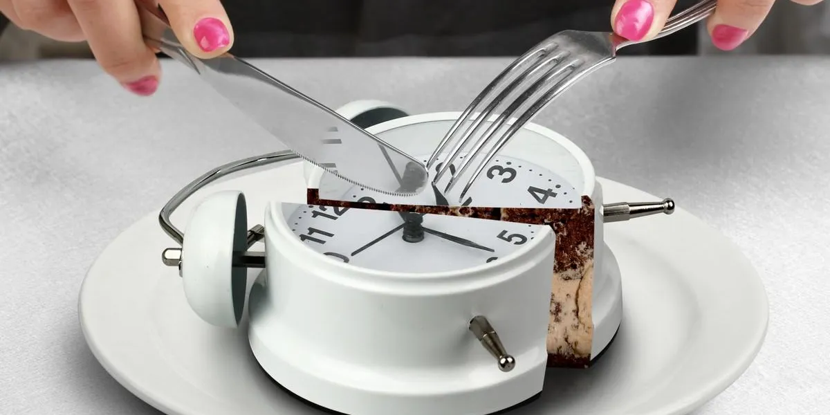 lunchtime concept, hand cut clock on plate