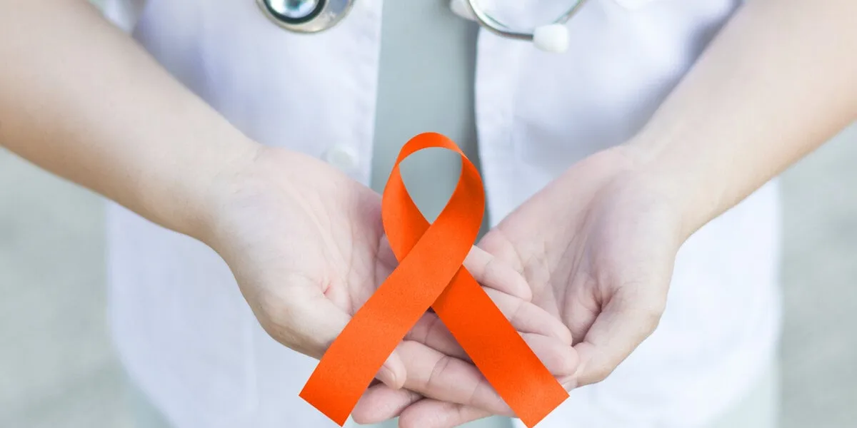 female doctor in white uniform with orange ribbon awareness in hand as stop sign for adhd,copd,cultural diversity,kidney cancer - renal cell carcinoma,leukemia, lupus,malnutrition,self injury,spinal