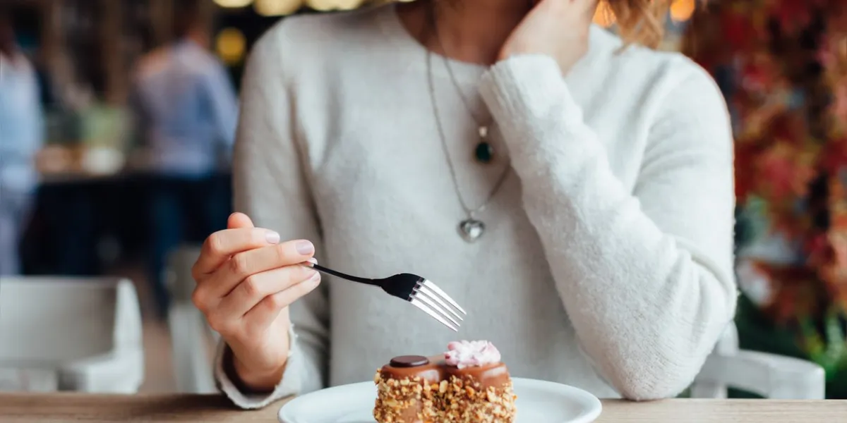 closeup of woman eating chocolate cake in a cafe
