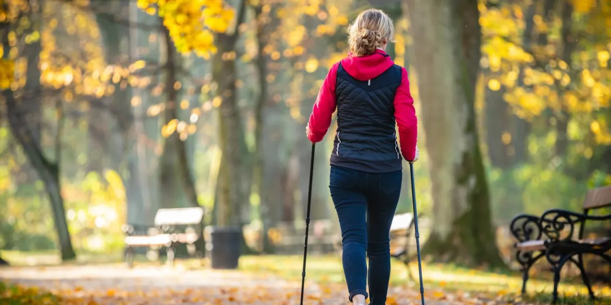 mid aged woman nordic walking in city park