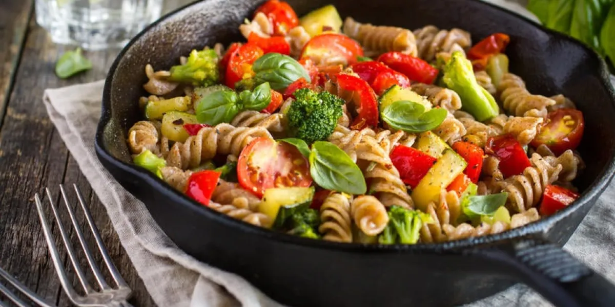 pâtes de blé entier avec des légumes sur une poêle en fonte