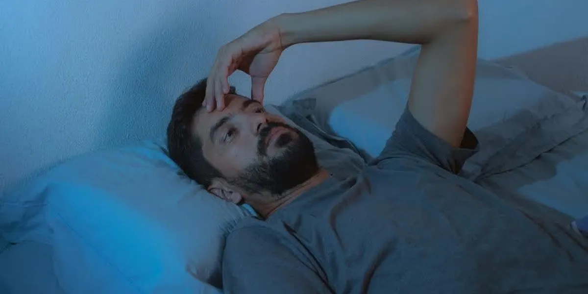 trouble du sommeil, l'insomnie jeune barbe homme couché sur le lit éveillé trouble du sommeil, l'insomnie jeune barbe homme allongé sur le lit éveillé