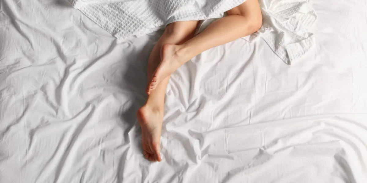 les jambes de la femme sur le lit