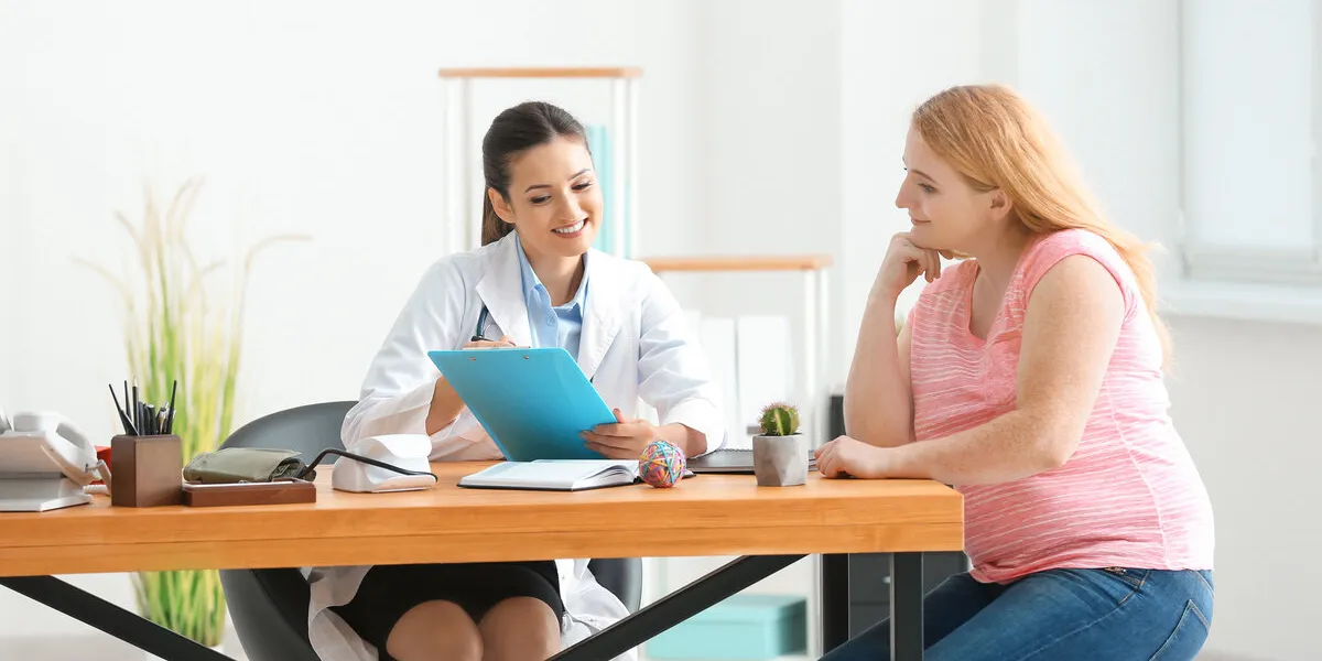 young female doctor consulting overweight woman in clinic
