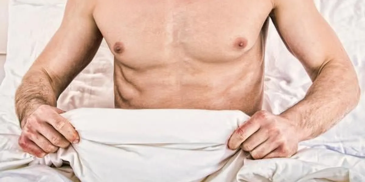 surpris à moitié nu jeune homme dans son lit regardant ses sous-vêtements à son pénis sous couvertures blanches feuille à badroom concept photo de la sexualité masculine et l'homme des problèmes de sexe, l'atmosphère domestique