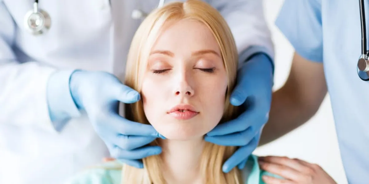 concept de soins de santé, de médecine et de personnes - chirurgien ou médecin vérifiant les ganglions lymphatiques du patient