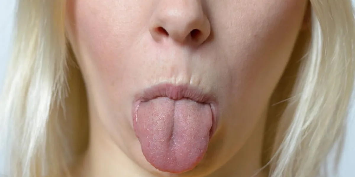 gros plan jeune femme blonde qui sort sa langue à la caméra