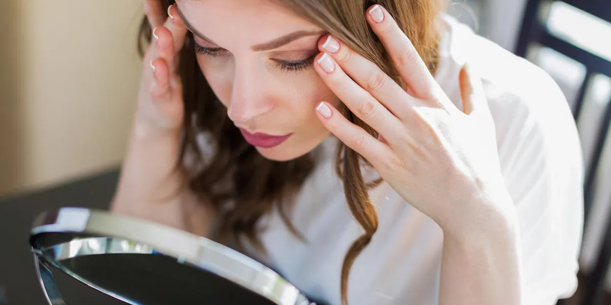 femme assise près du miroir et se maquiller