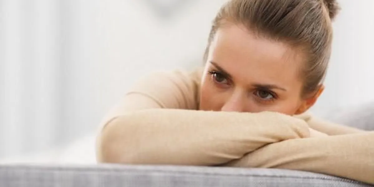 stressé jeune femme assise sur le canapé
