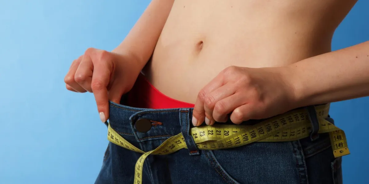 gros plan de la taille mince de la femme en jeans avec un ruban à mesurer