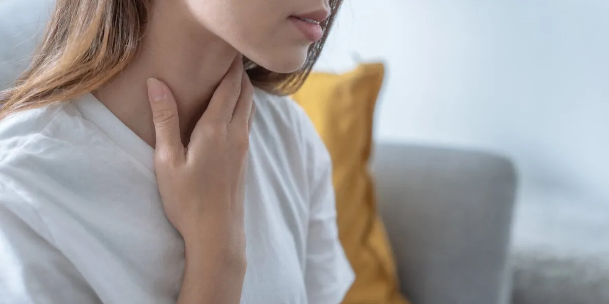 asian woman suffering from sore throat, acid reflux