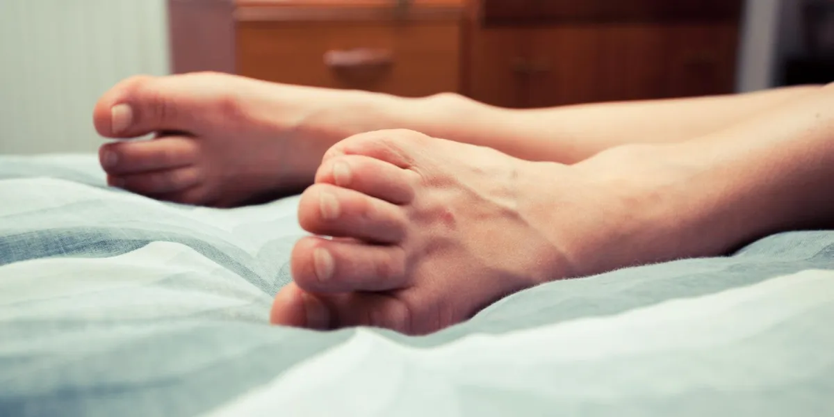 pieds de la jeune femme sur le lit à la maison