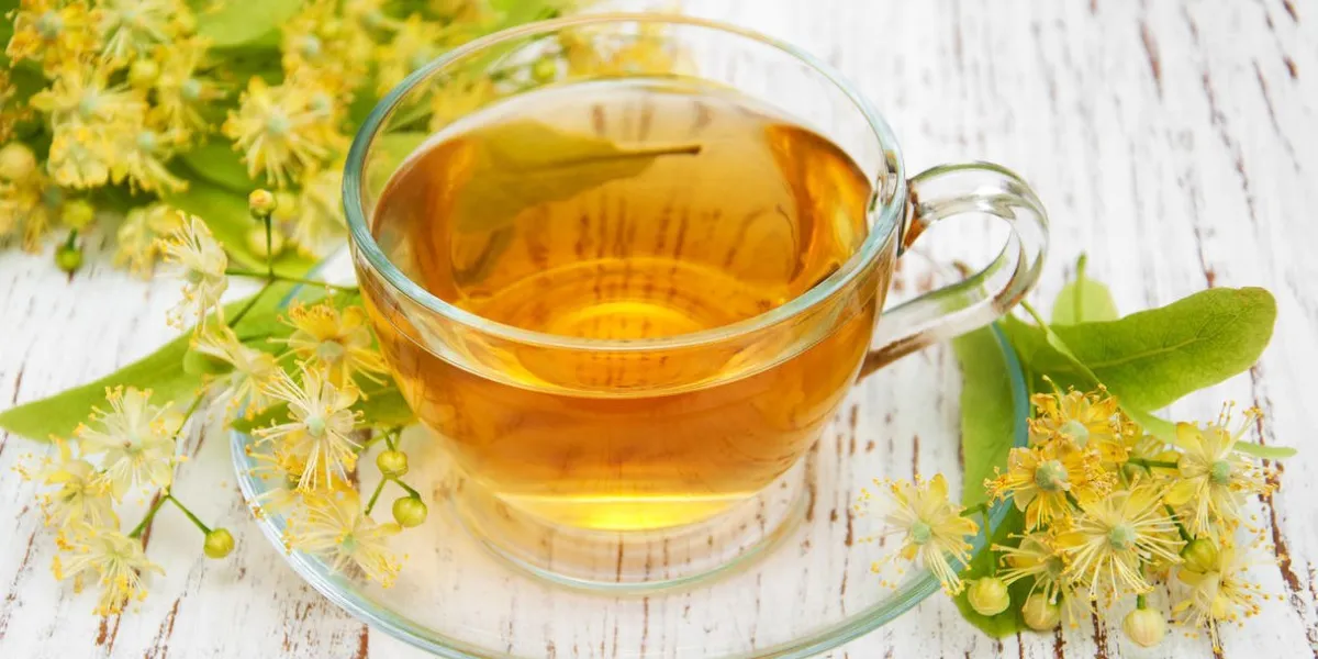 tasse de tisane avec des fleurs de tilleul sur un vieux fond en bois