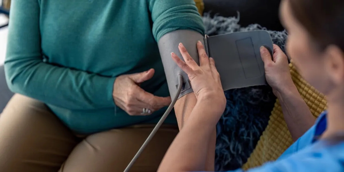 unrecognizable senior woman visited by home care specialist getting her blood pressure measured nurse teaching elderly woman to measure blood pressure at home home care for people in retirement