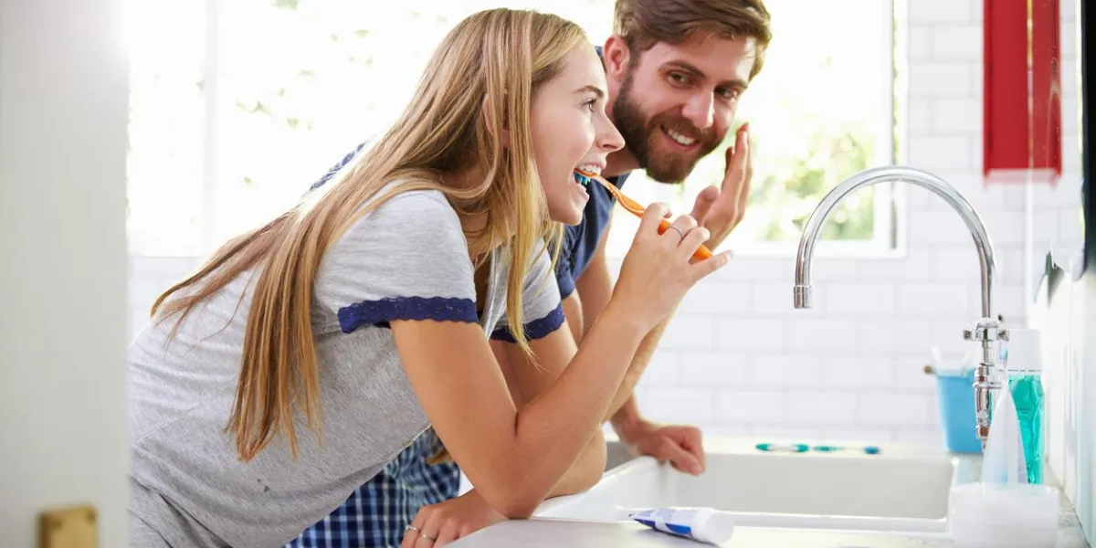 couple en pyjama se brosser les dents et mettre un hydratant ,, sourire