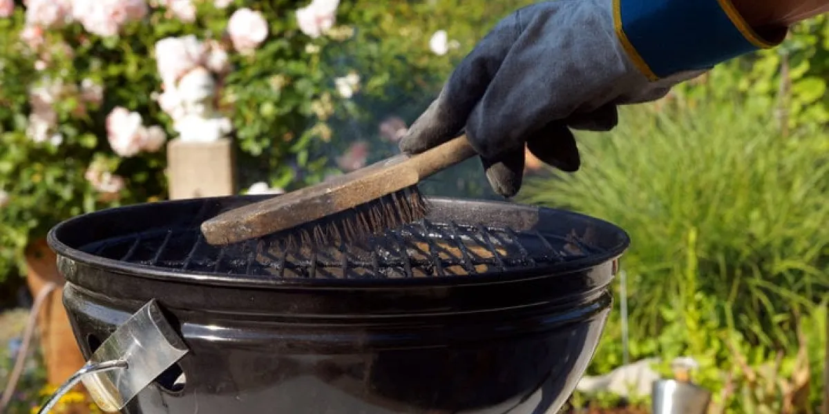 cleaning a grill male hand with gloves cleans stiff brush round grill before cooking scrubbing utensil used for cleaning a dirty grill
