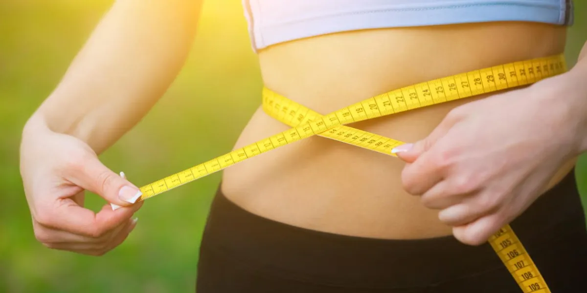 sport girl measuring waist with yellow measuring tape reducing excess weight healthy lifestyle