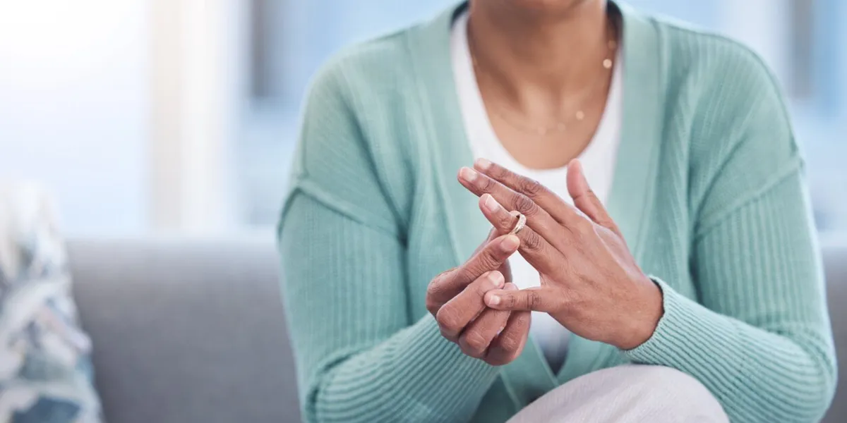 doubt, stress and hands taking off ring for a divorce after marriage conflict, toxic relationship or cheating anxiety, mental health or sad senior woman removing her engagement ring after fighting