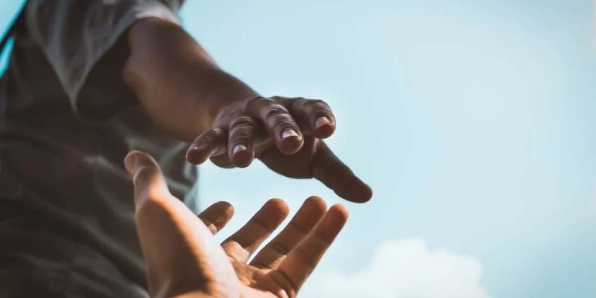 help concept hands reaching out to help each other in dark tone