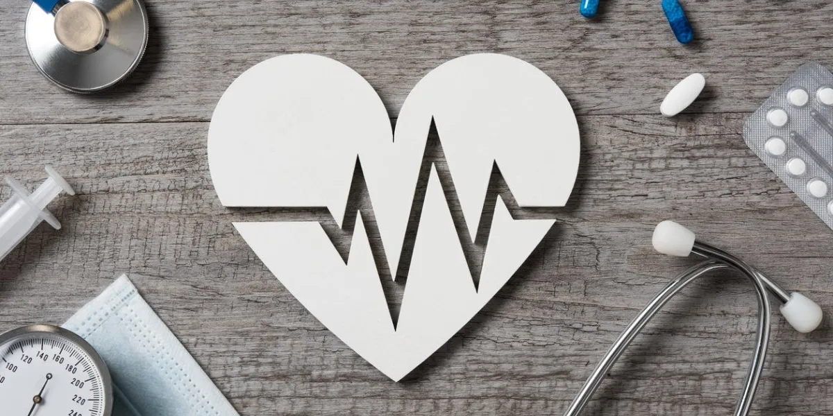 top view of doctor desk with heart shape showing cardiac signs, medicine and stethoscope high angle view of white shaped heart icon with electrocardiogram cardiology and healthcare conceptr
