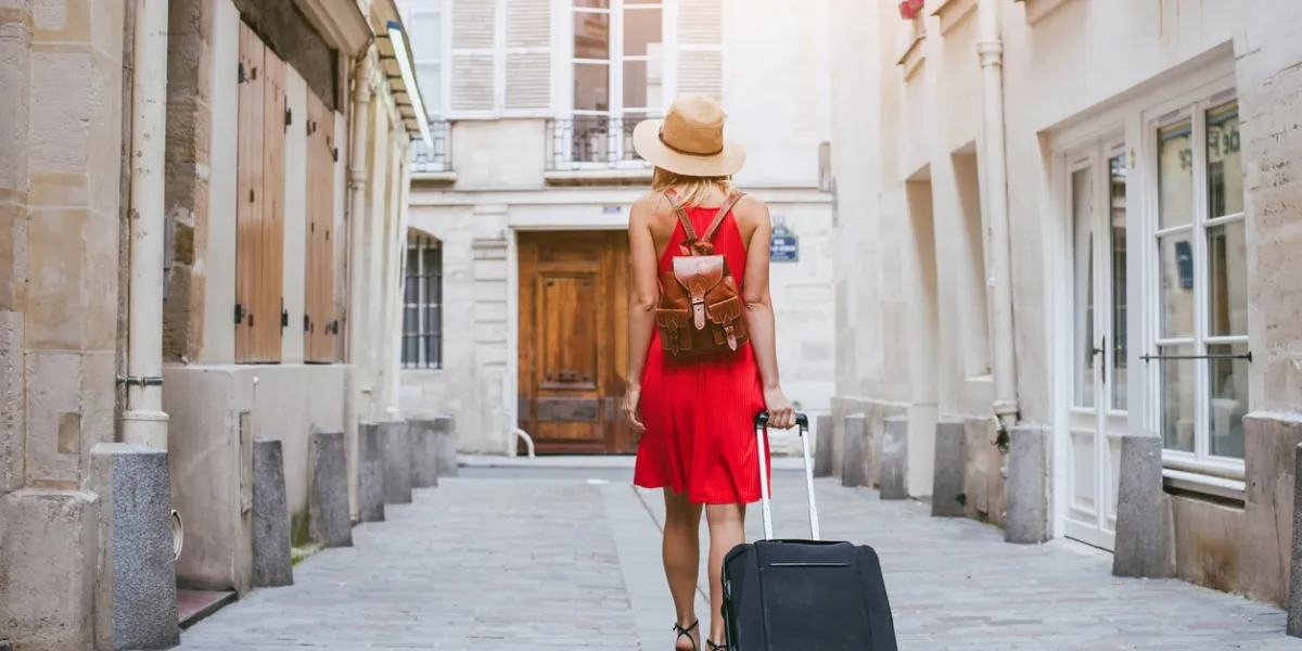 travel background, woman tourist walking with suitcase on the street in european city, tourism in europe