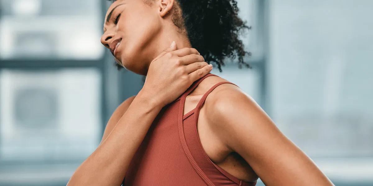 fitness, neck pain or black woman in gym with pain or injury after workout exercises or body training alone emergency, african girl or injured sports athlete holding sore muscle after bad accident