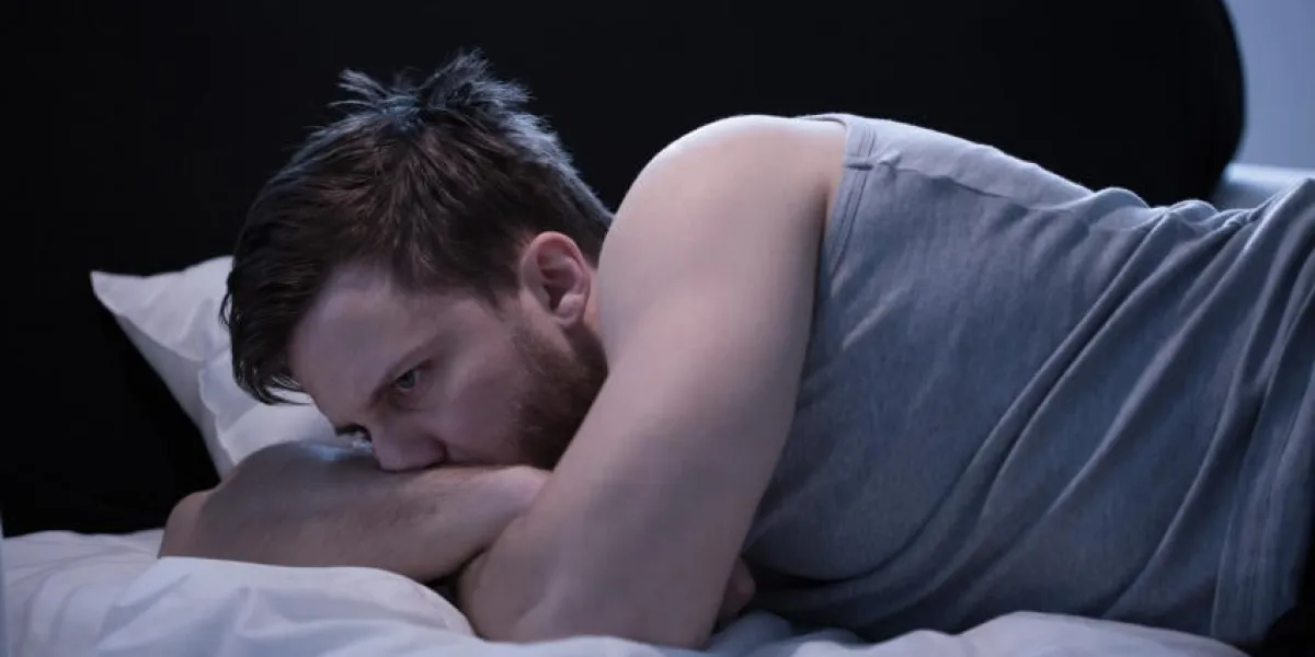 homme souffrant d'insomnie causée par un long voyage aérien