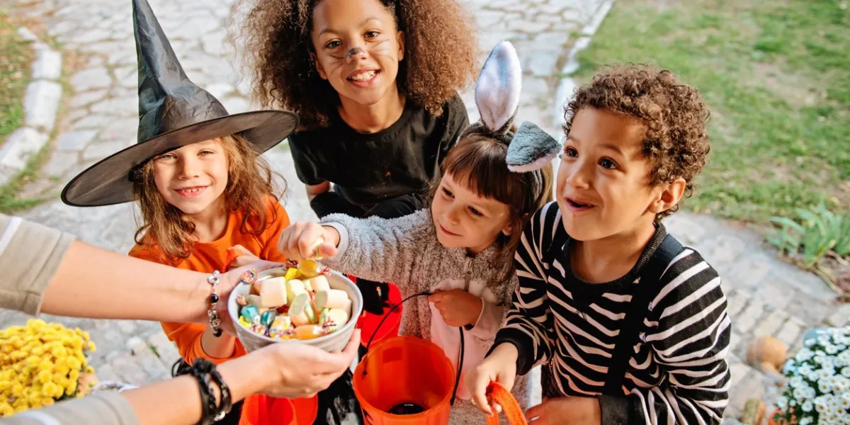 children in halloween costumes in front of an old house
