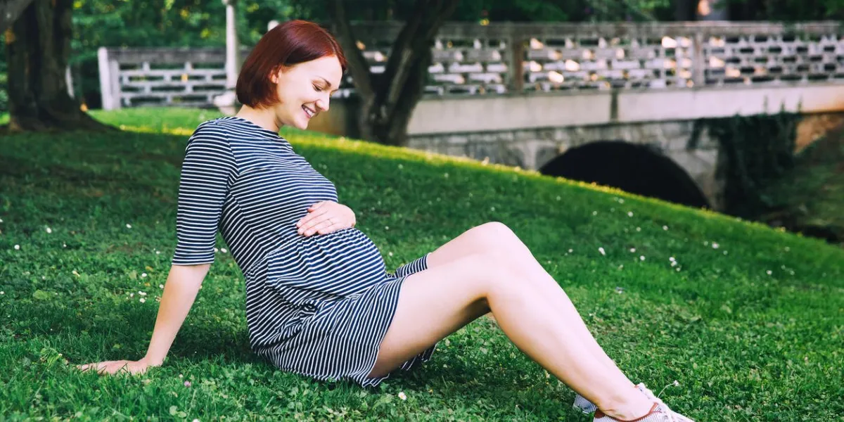 belle femme enceinte en robe sur la nature, à l'extérieur avec copie espace femme enceinte détient les mains sur le ventre sur fond naturel d'herbe verte dans le parc grossesse, attente, nouveaux concepts de la vie