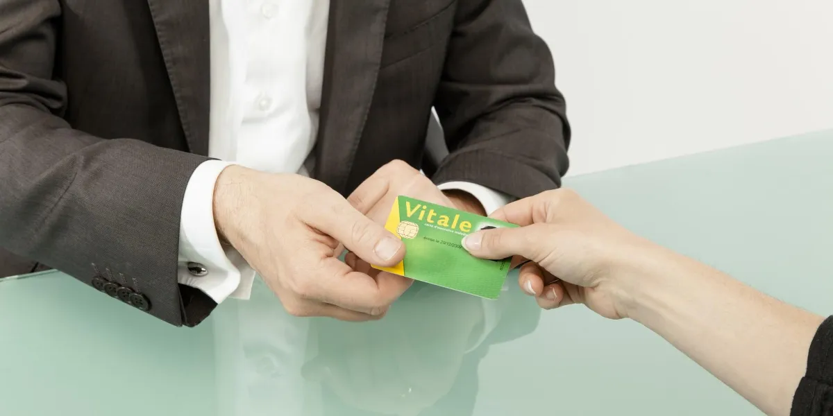 un patient donne sa carte vitale au praticien de santé