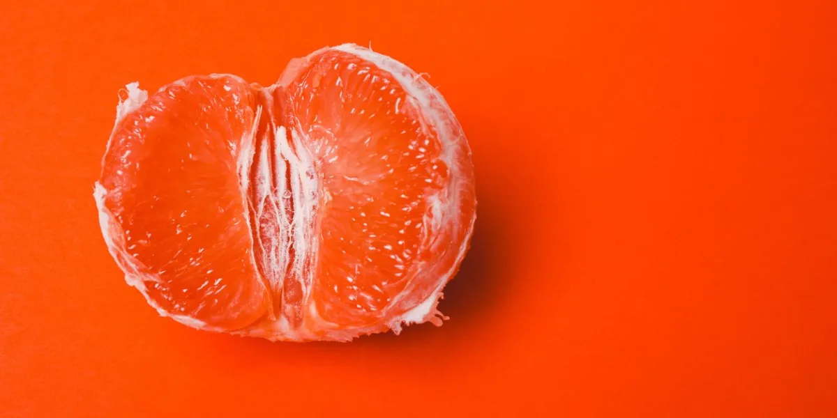 concept sex, masturbation grapefruit, vagina symbol on orange background