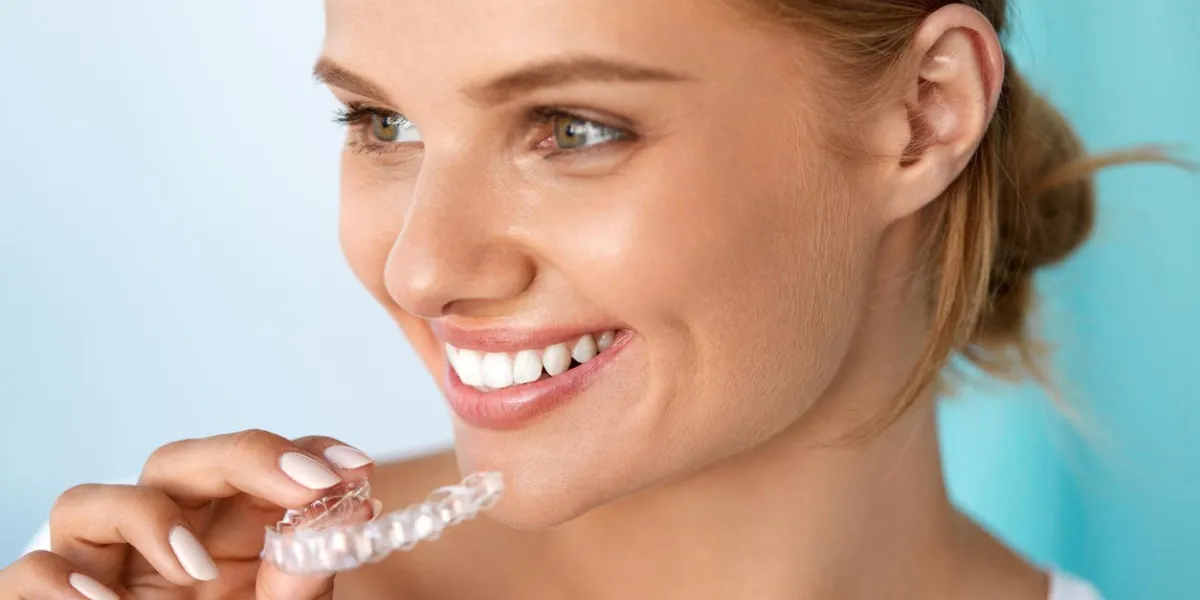 teeth whitening beautiful smiling woman with white smile, straight teeth using teeth whitening tray girl holding invisible braces, teeth trainer dental treatment concept high resolution image