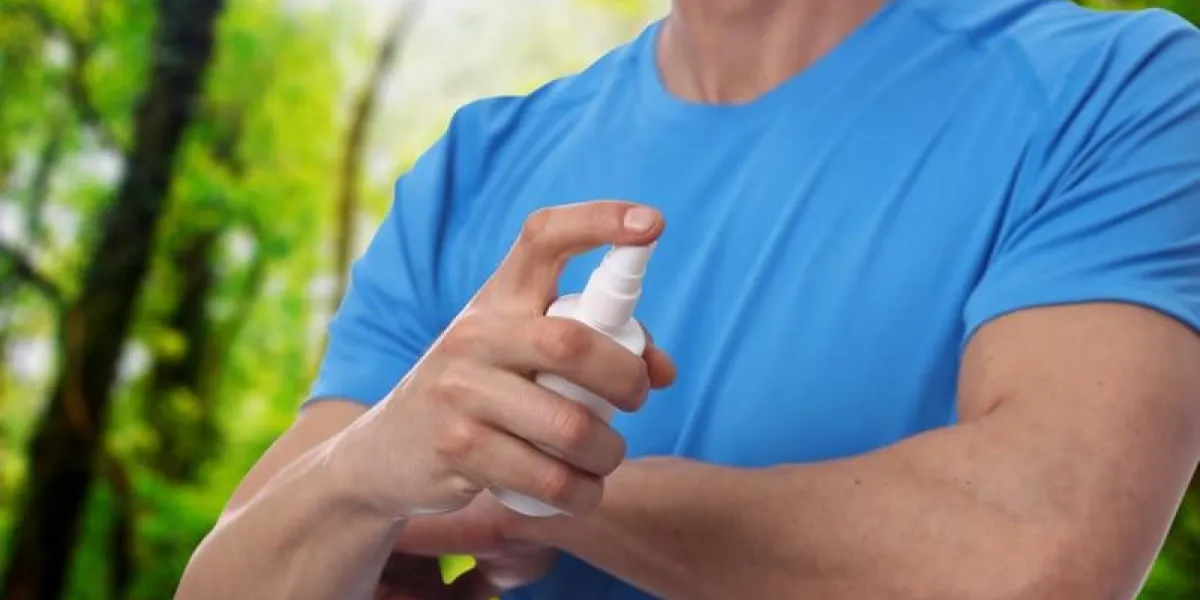 moustique répulsif contre les moustiques à l'aide d'un vaporisateur insectifuge provenant d'une botte en forêt