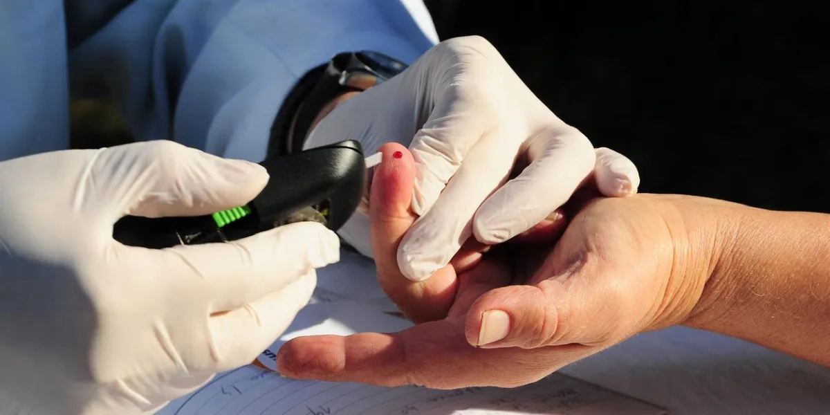un technicien de laboratoire prend du sang du doigt du patient pour un test de glucose