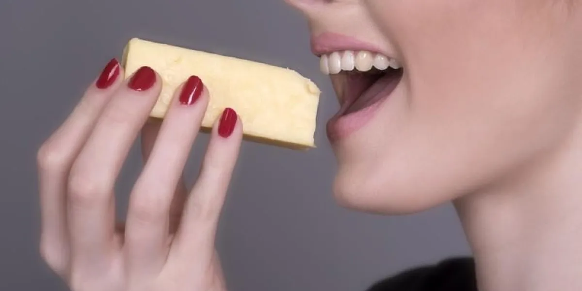 woman eating a chunk of cheese
