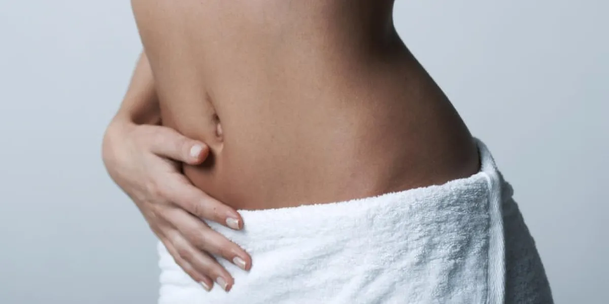 partie du corps belle femme vêtu d'une serviette blanche sur fond clair