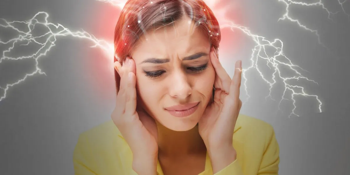 the young woman's portrait with pain emotions on gray background concept headache