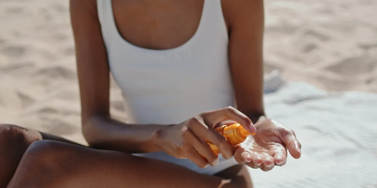 hands spray sun protection oil closeup attractive girl sunbathing at seashore