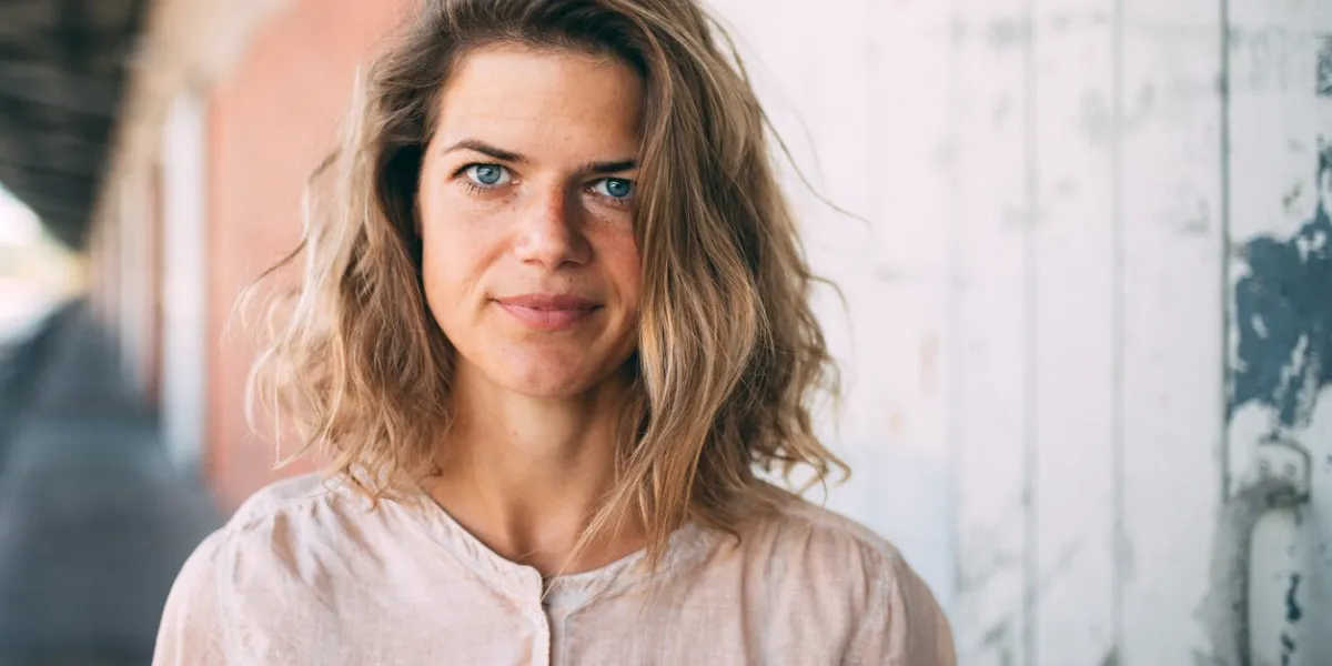 portrait of smiling woman standing against wall