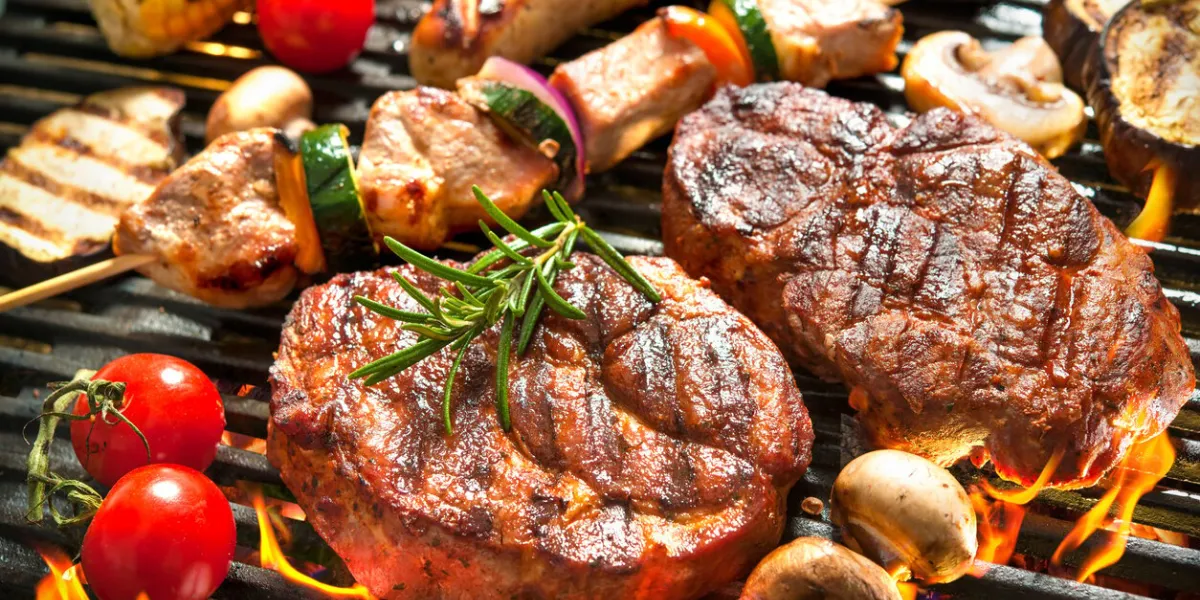 assorted delicious grilled meat with vegetable over the coals on a barbecue