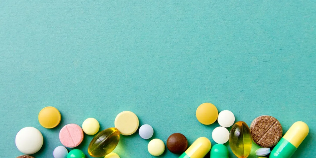 many colorful pills on red background with copy space pattern , identification of pills