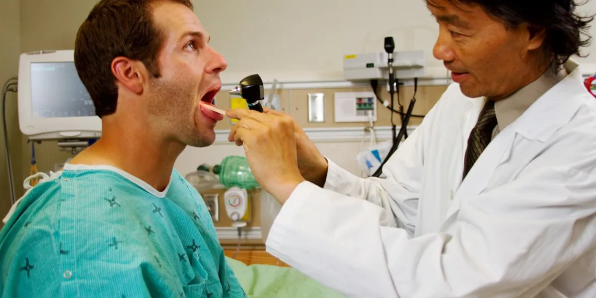 médecin examinant la gorge sur le patient en cas d'urgence