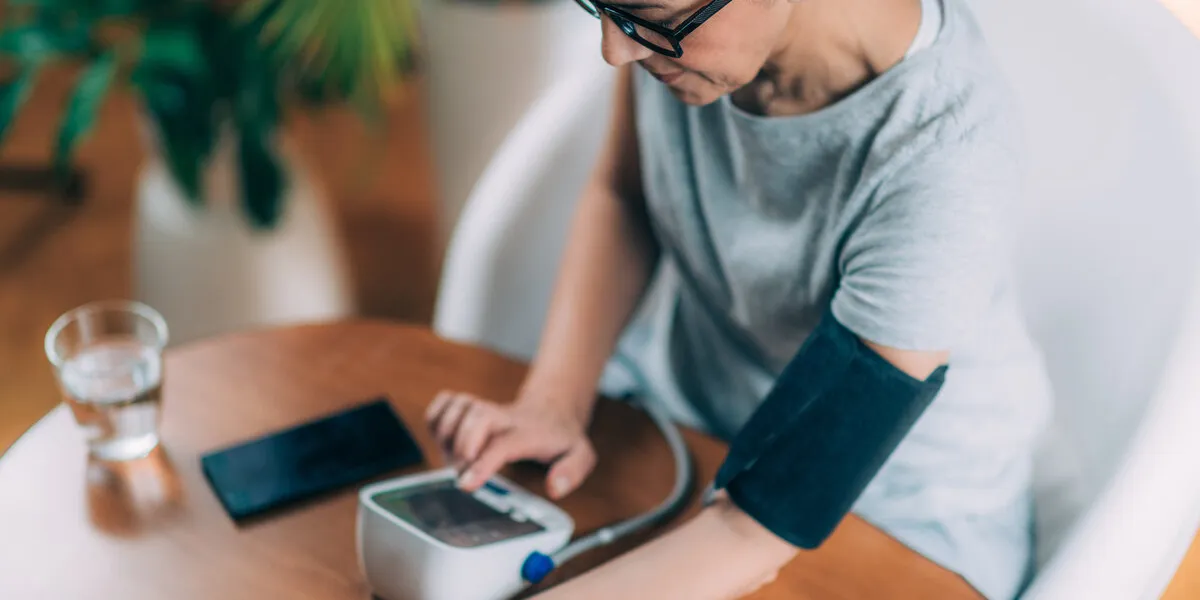 senior woman using blood pressure meter