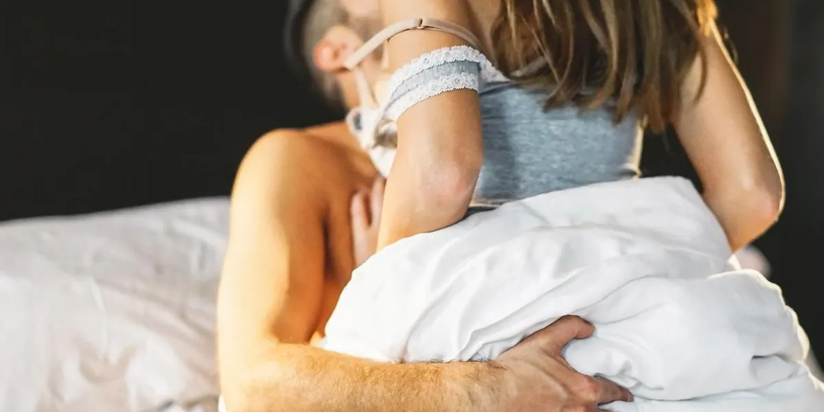 beau jeune couple passionné ayant des rapports sexuels sur le lit à la maison - moments intimes et sensuels d'un couple faisant l'amour dans la chambre à coucher - concept sexuel et érotique - filtre vintage - mise au point sur la main masculine