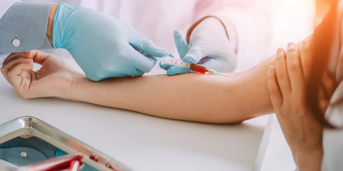 close up hand of nurse, doctor or medical technologist in blue gloves taking blood sample from a patient in the hospital