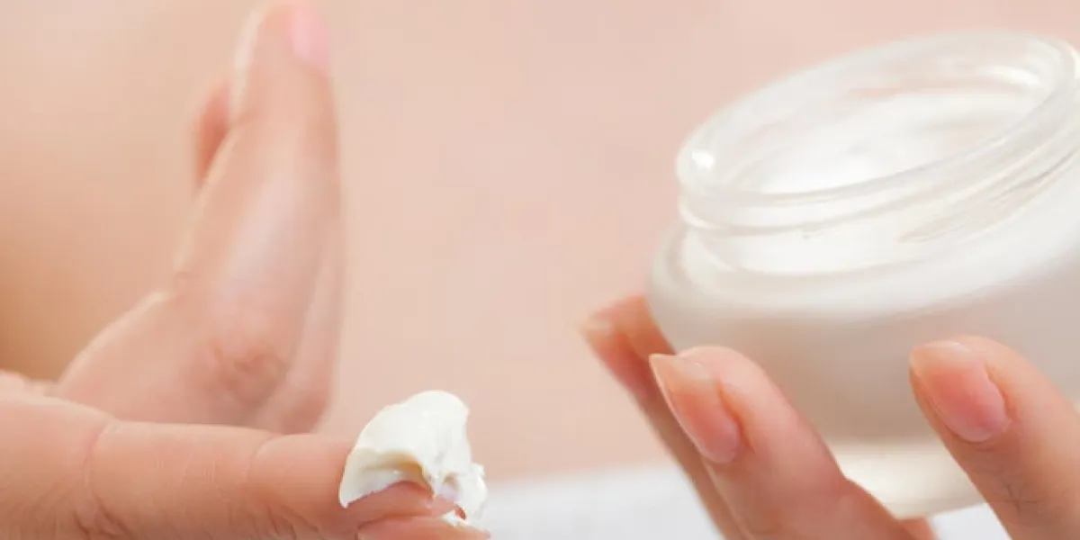 soins de la peau closeup de cosmétique jeune femme fille prenant soin de son teint sec en appliquant crème hydratante isolé traitement de beauté